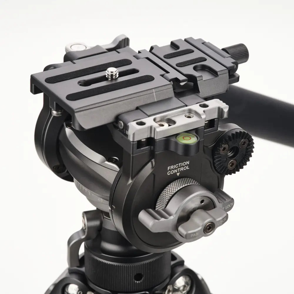Close-up of a camera tripod head with mechanical components on a white background