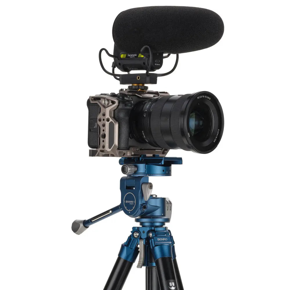 Camera with microphone on a tripod against a white background