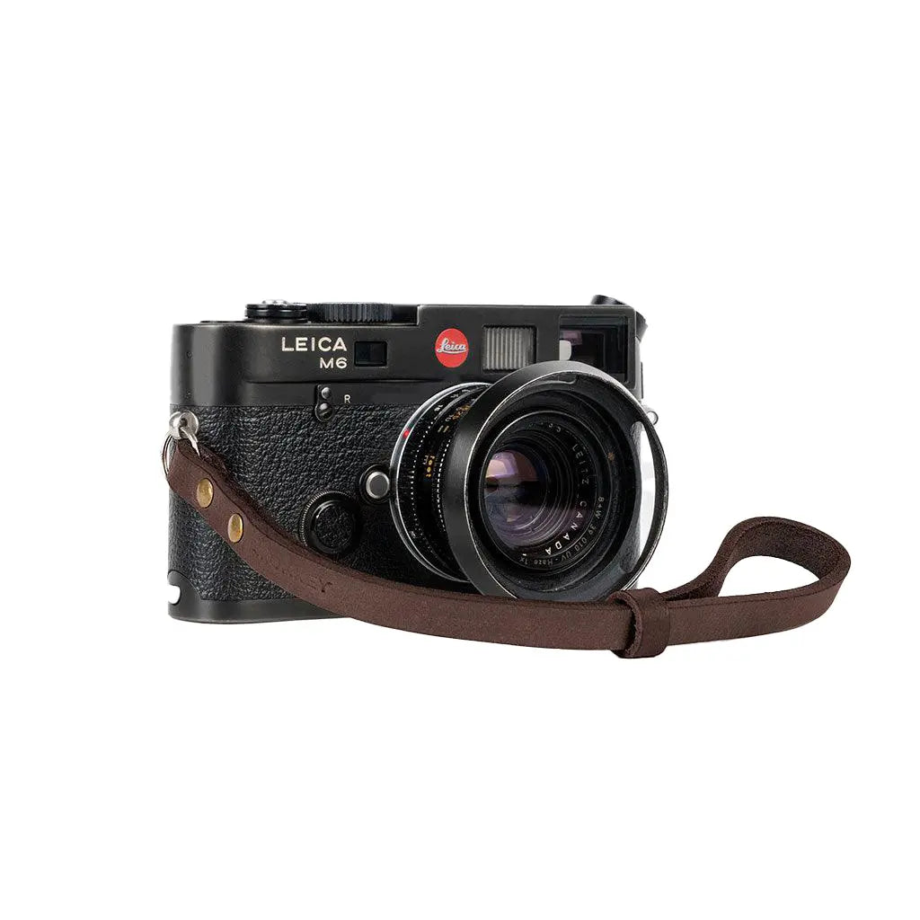 Leica camera with a brown strap on a white background