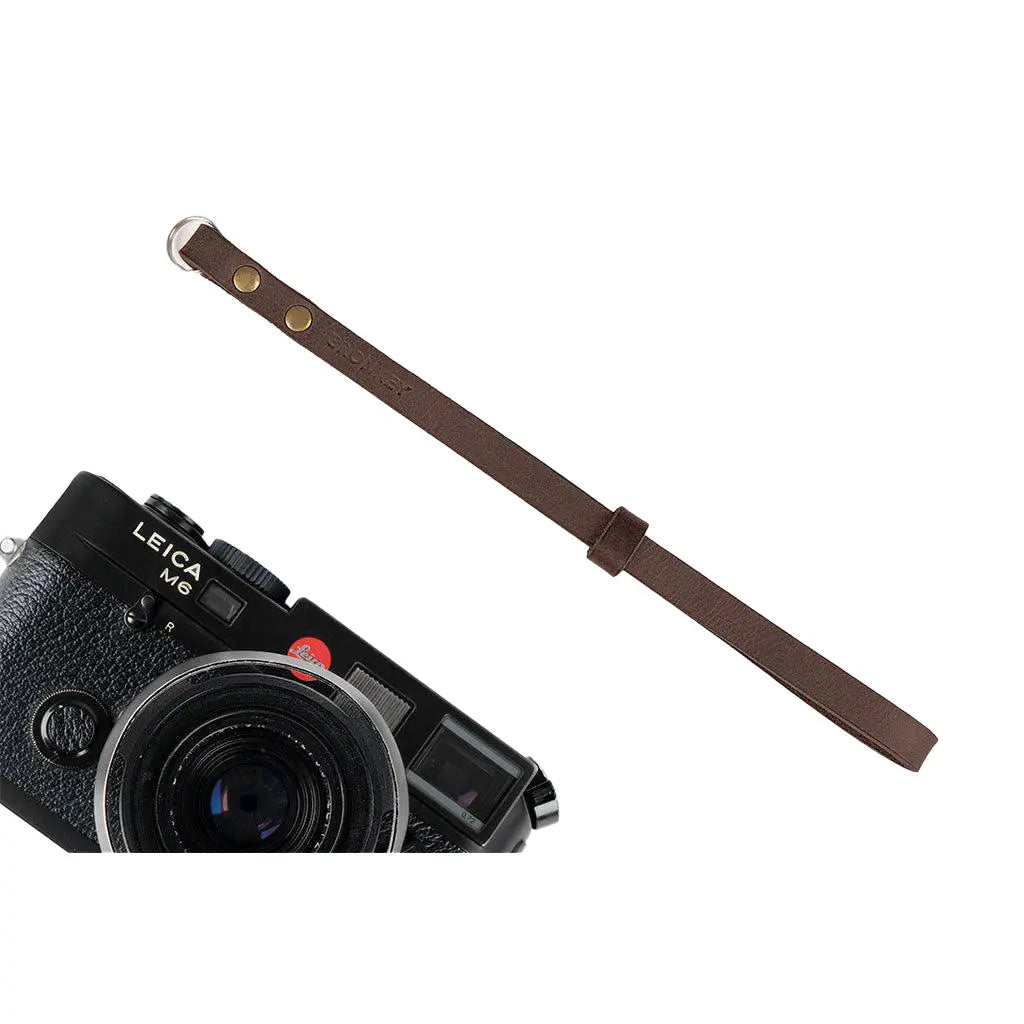 Leica camera with a black camera strap on a white background