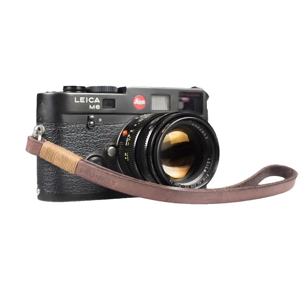 Leica camera with leather strap on a white background