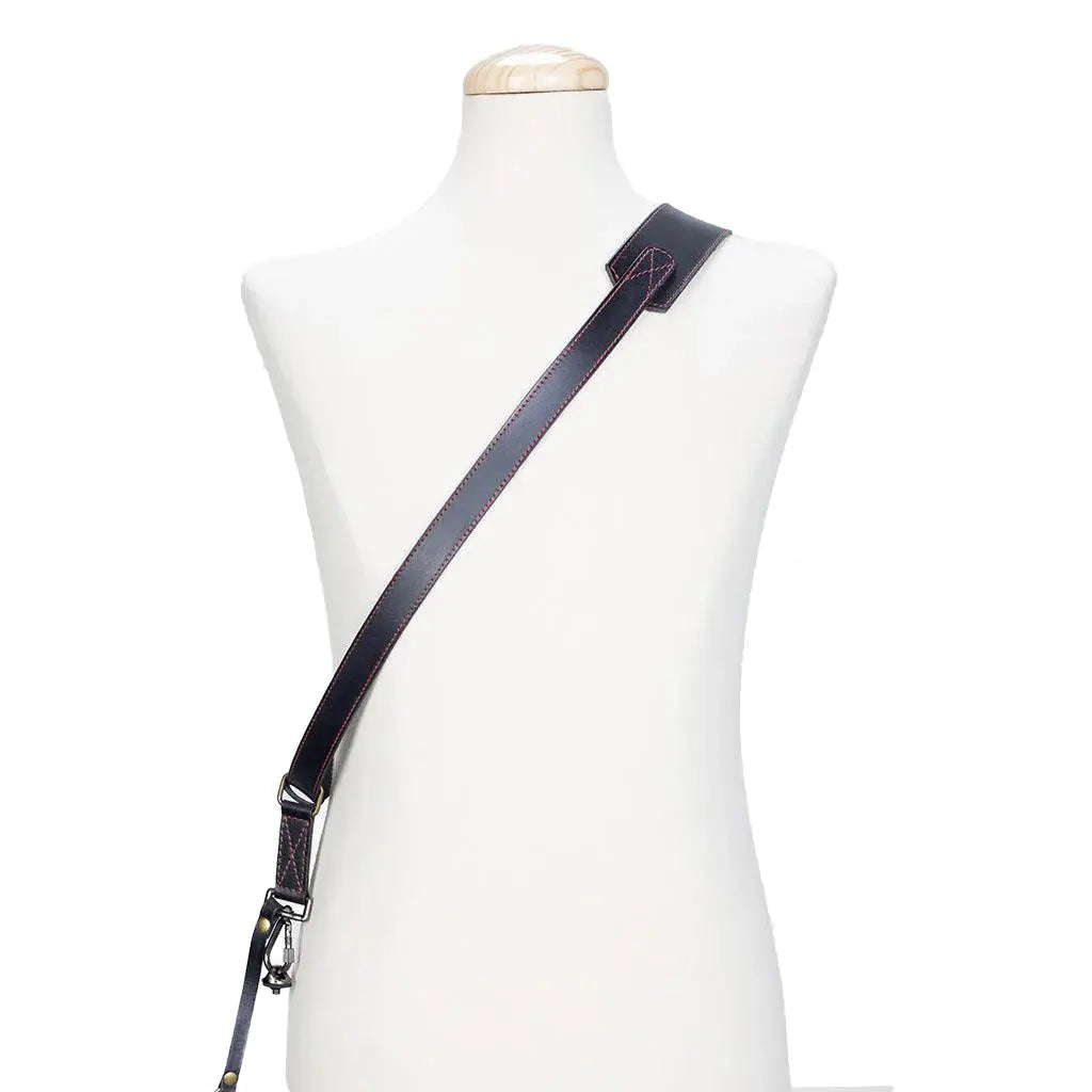 Black leather crossbody strap on a mannequin with a white background