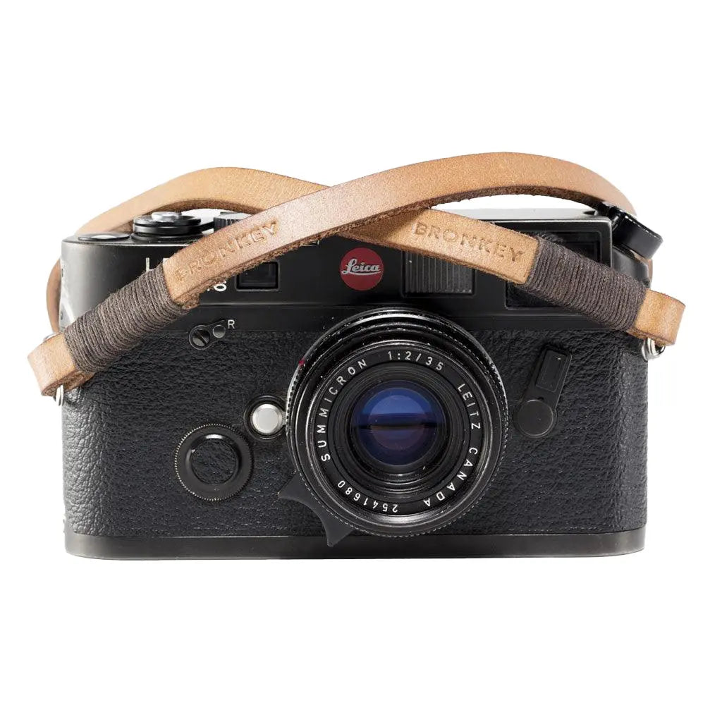 Black camera with a leather strap on a white background