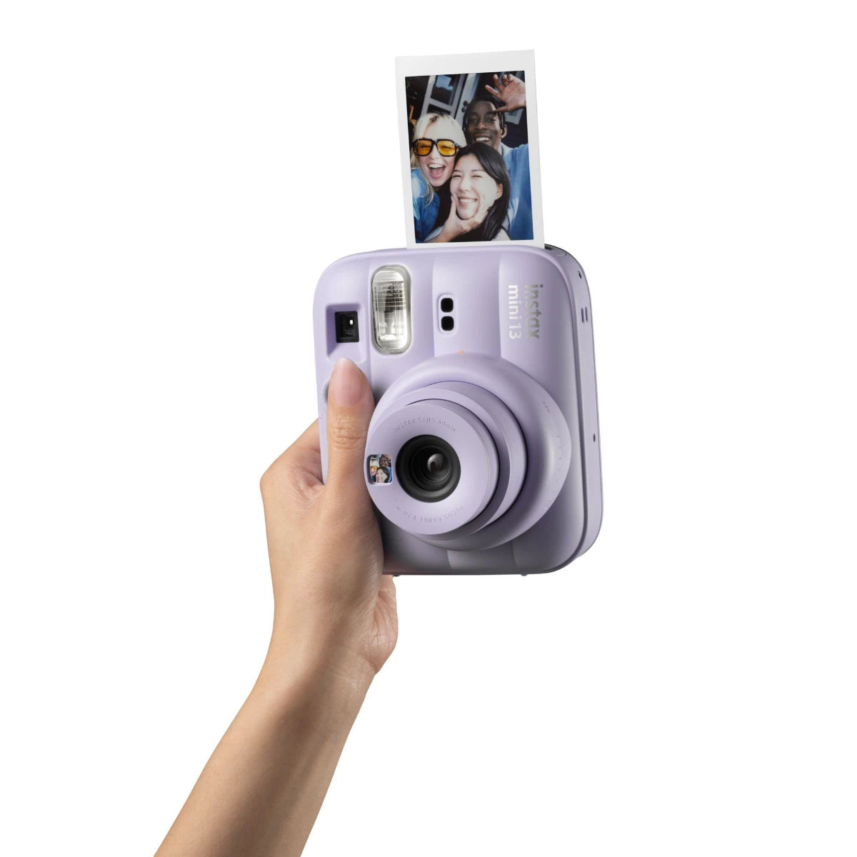 Lavender instant camera held by a hand with a photo attached on a white background