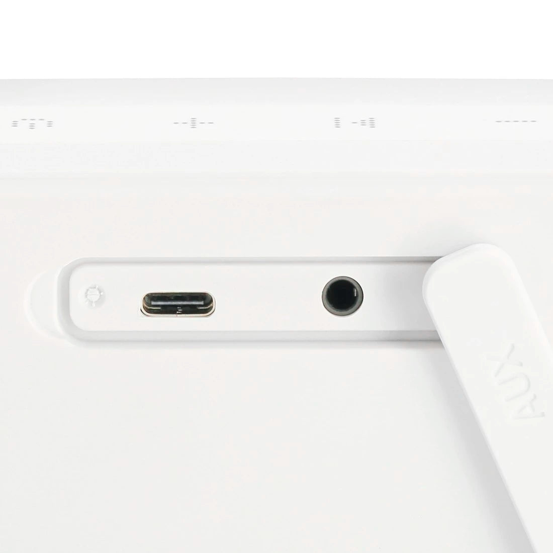 Close-up of a white electronic device with USB-C port and headphone jack on a light gray background