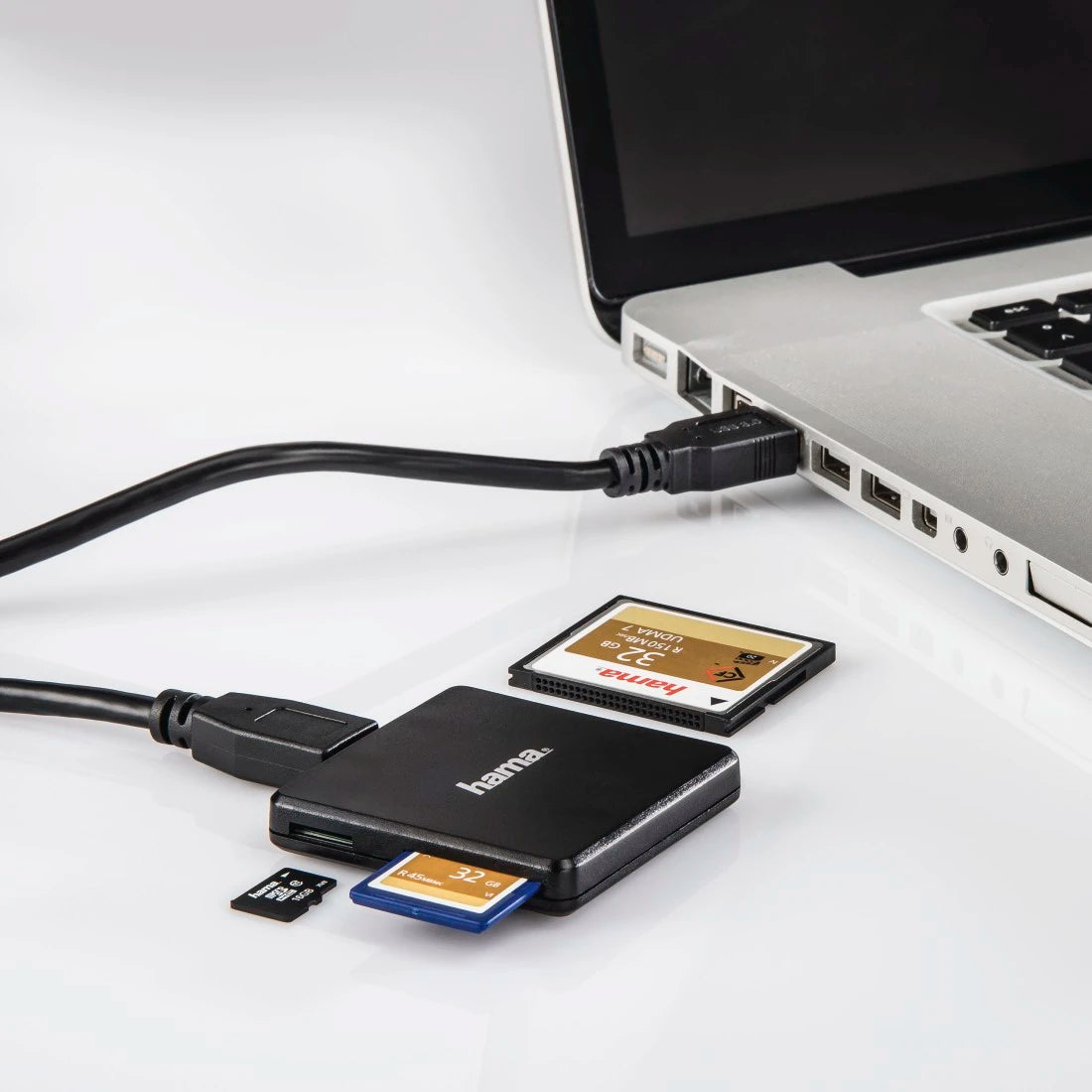 Hama multi-card reader connected to a laptop with memory cards on a white background