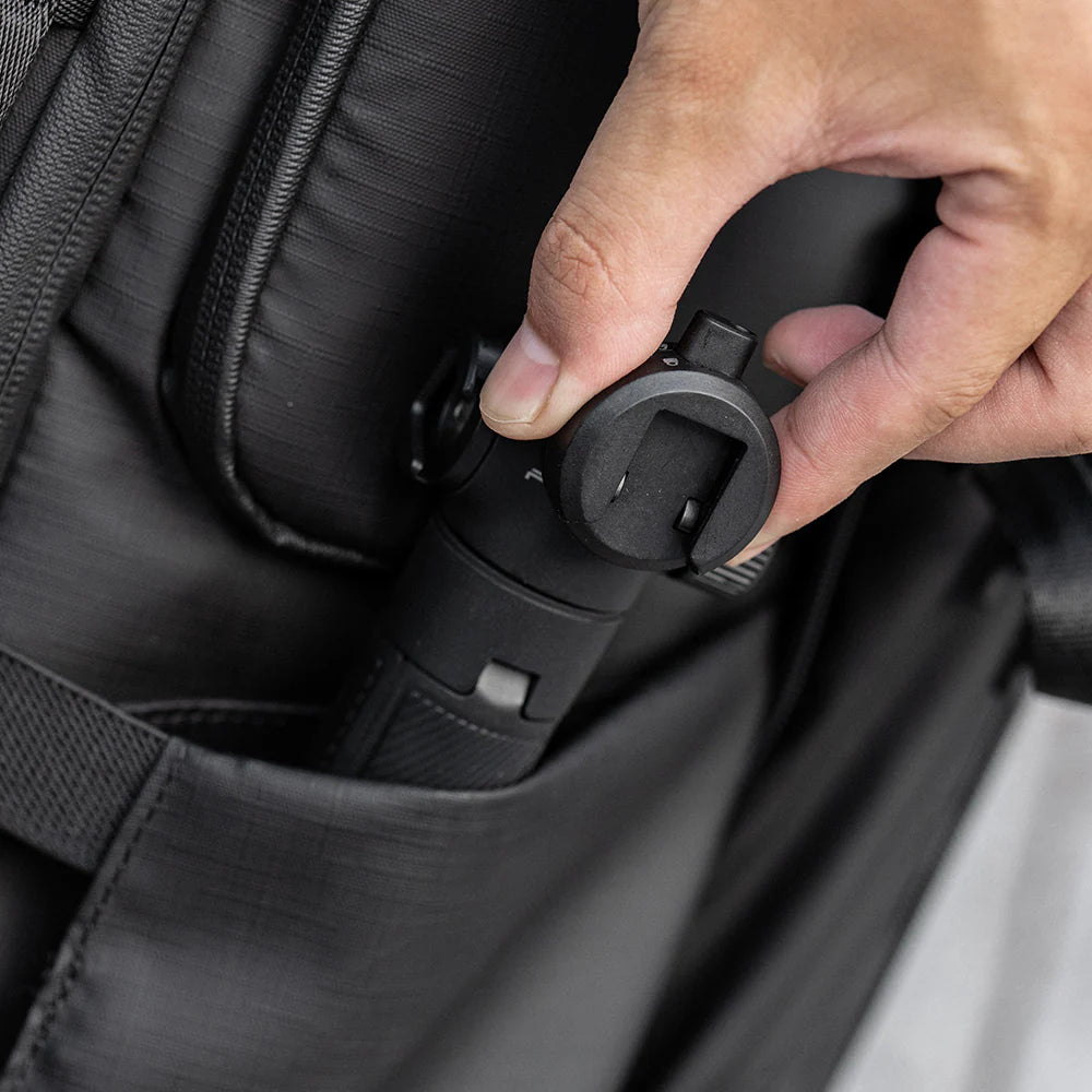 Hand zipping a black backpack