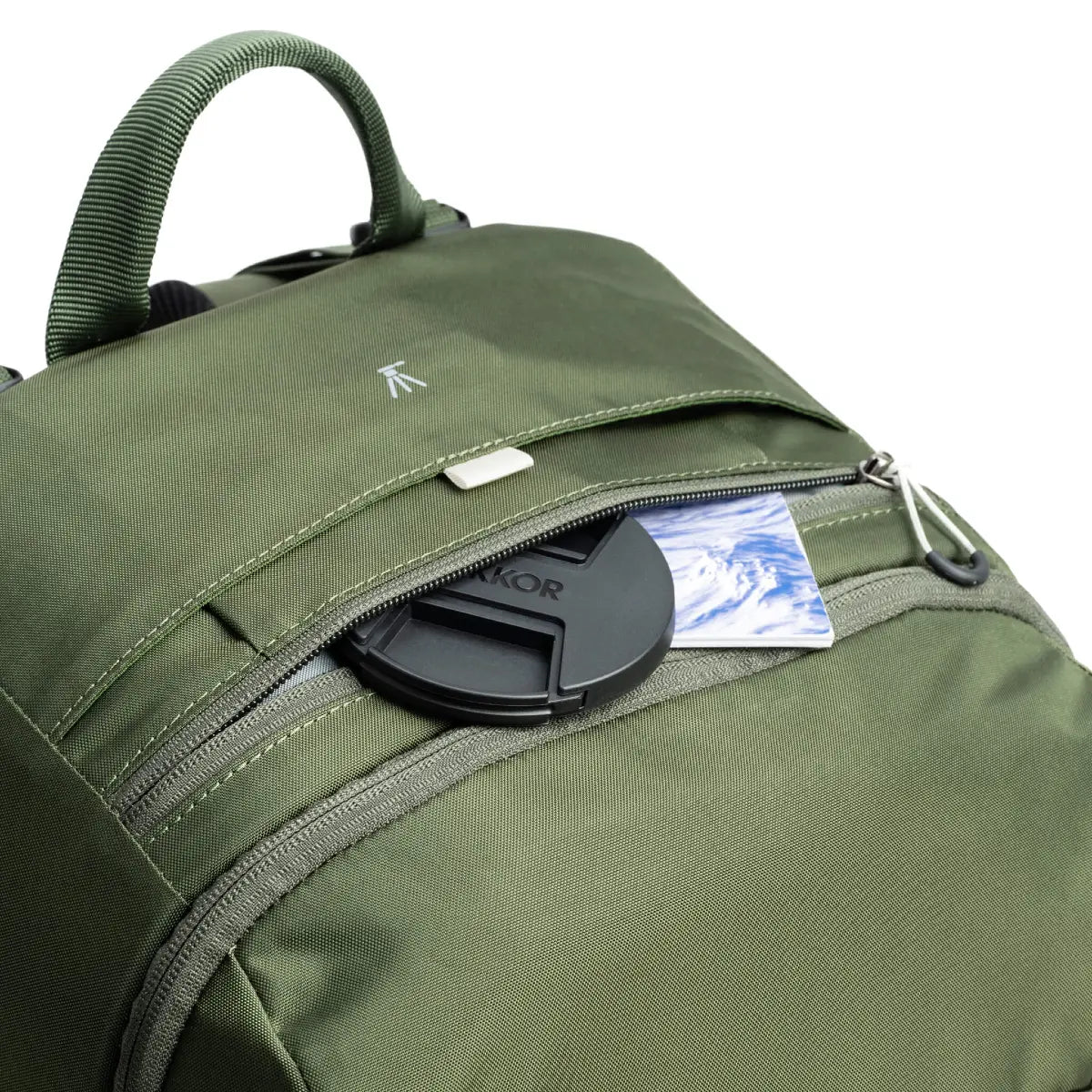 Green backpack with a lens cap and brand label on a white background