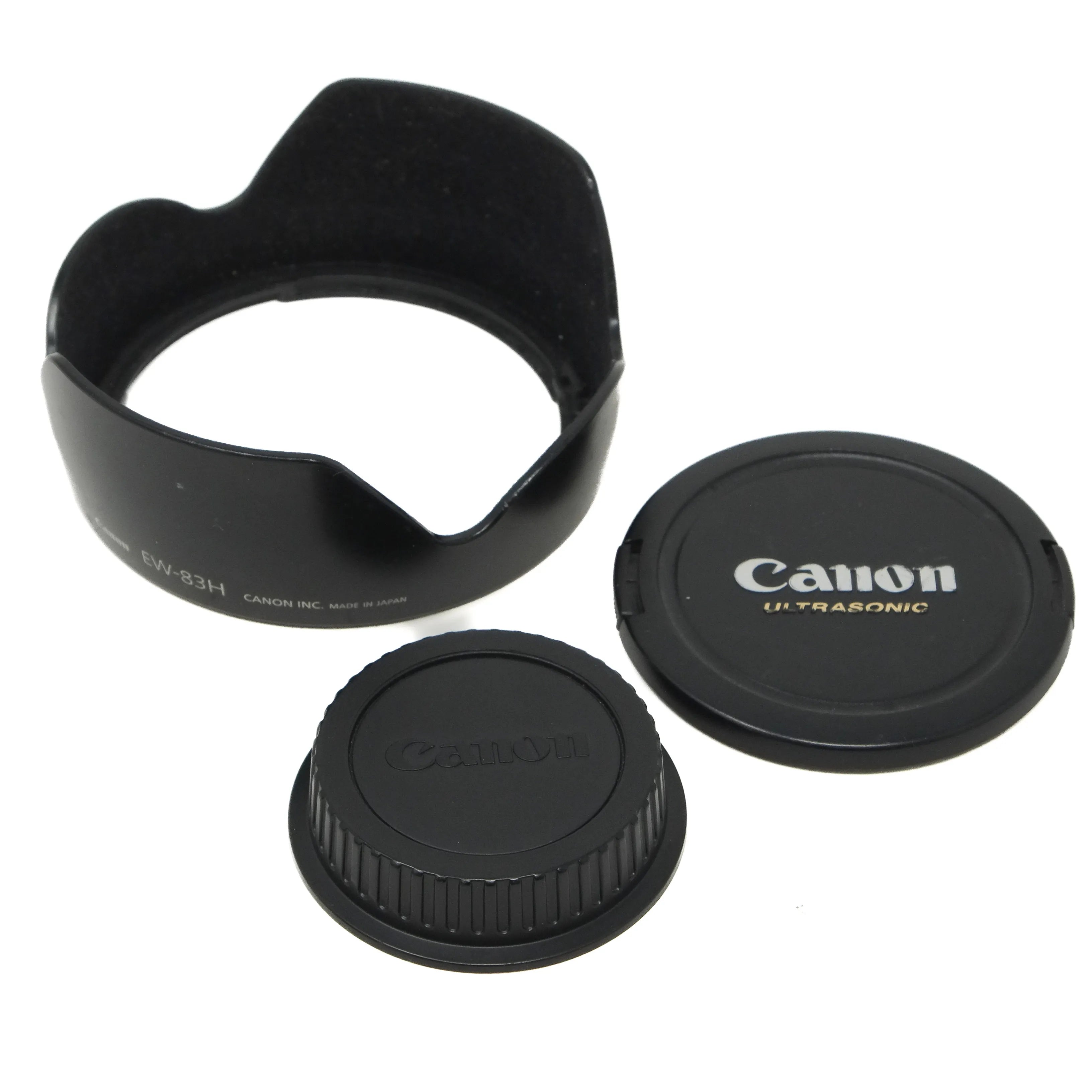 Canon lens cap, lens hood, and front cap on a white background