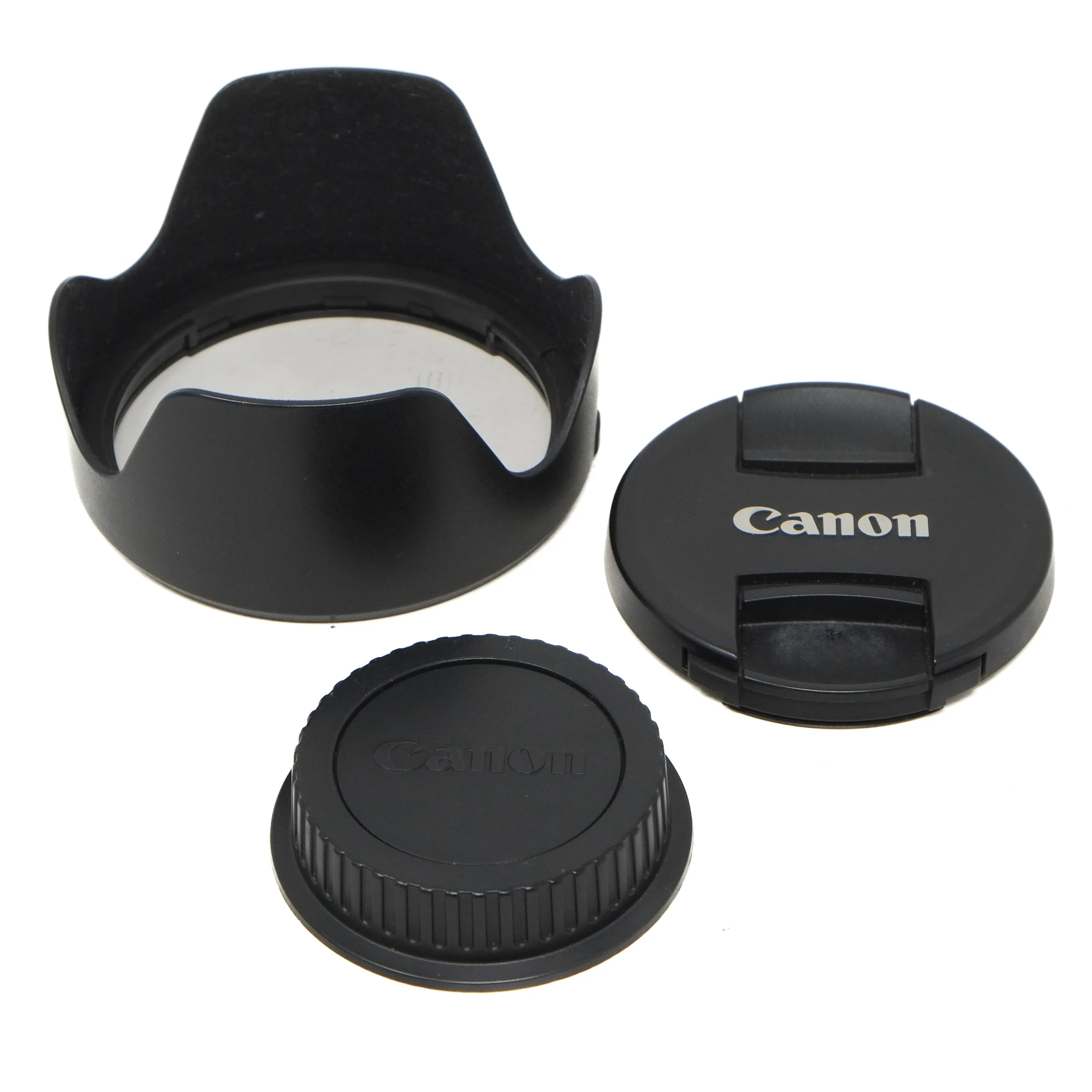 Canon camera lens accessories including a lens hood, front cap, and rear cap on a white background.