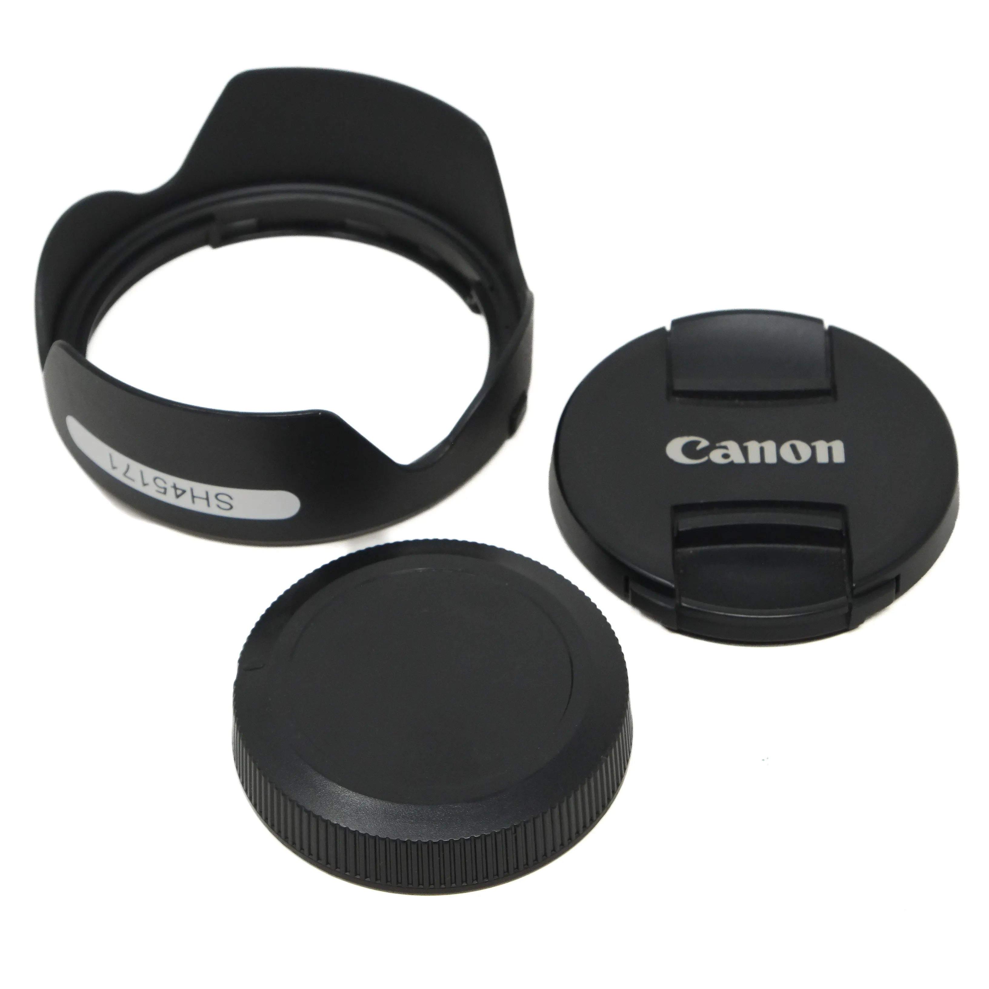 Camera lens accessories including a lens hood, front cap, and rear cap on a white background.