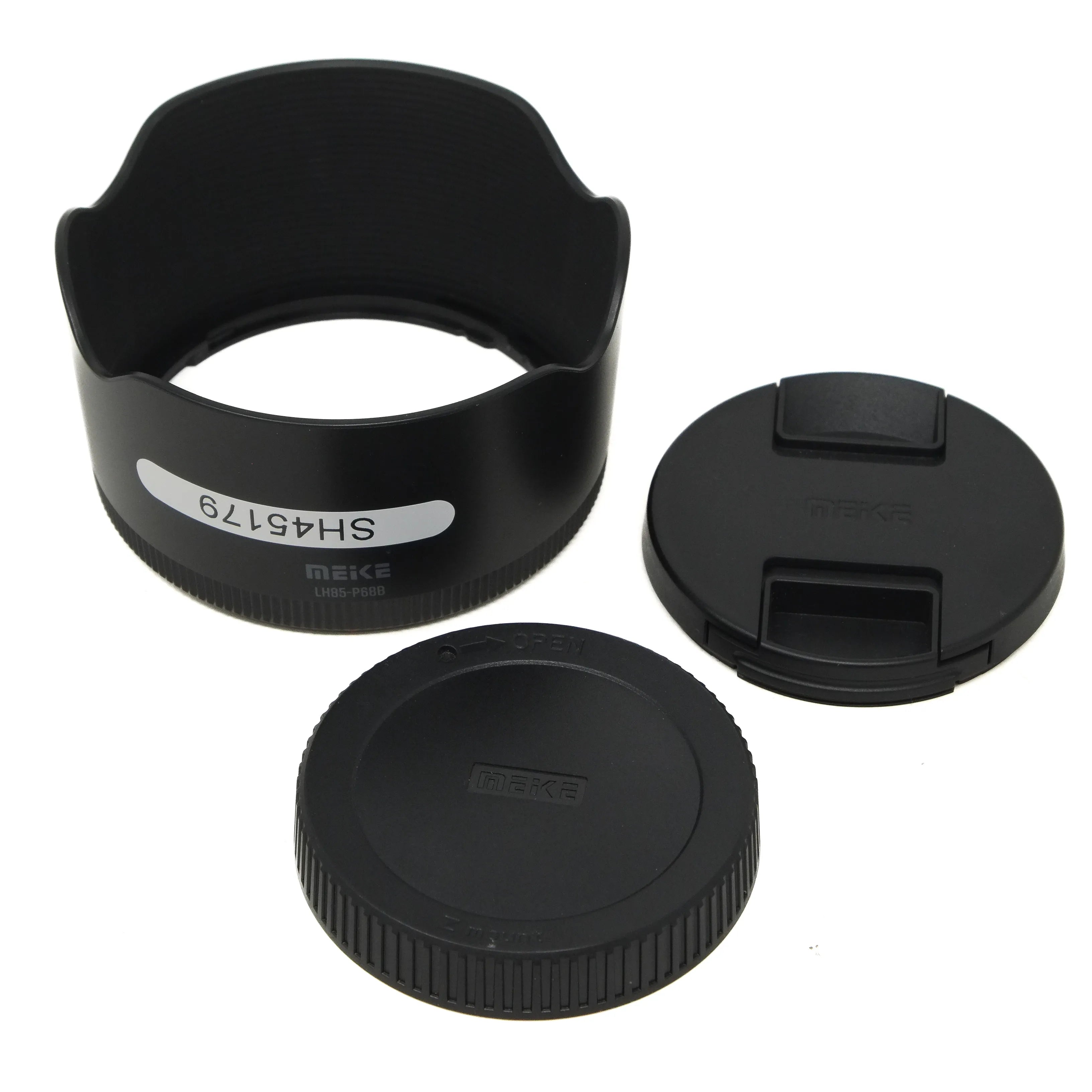 Set of black camera lens accessories including a hood, front cap, and rear cap on a white background.