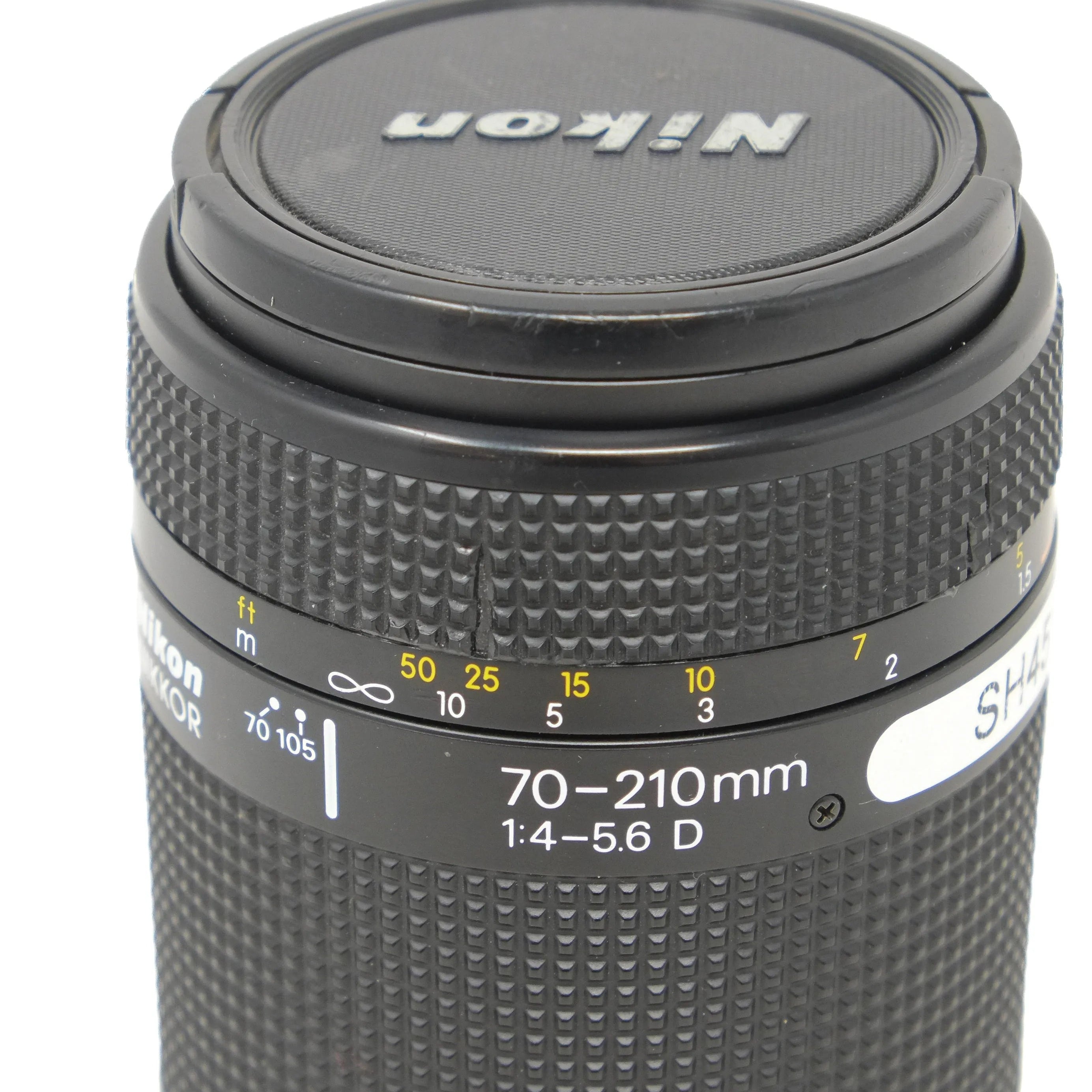 Nikon camera lens with focus scale and model number on a white background