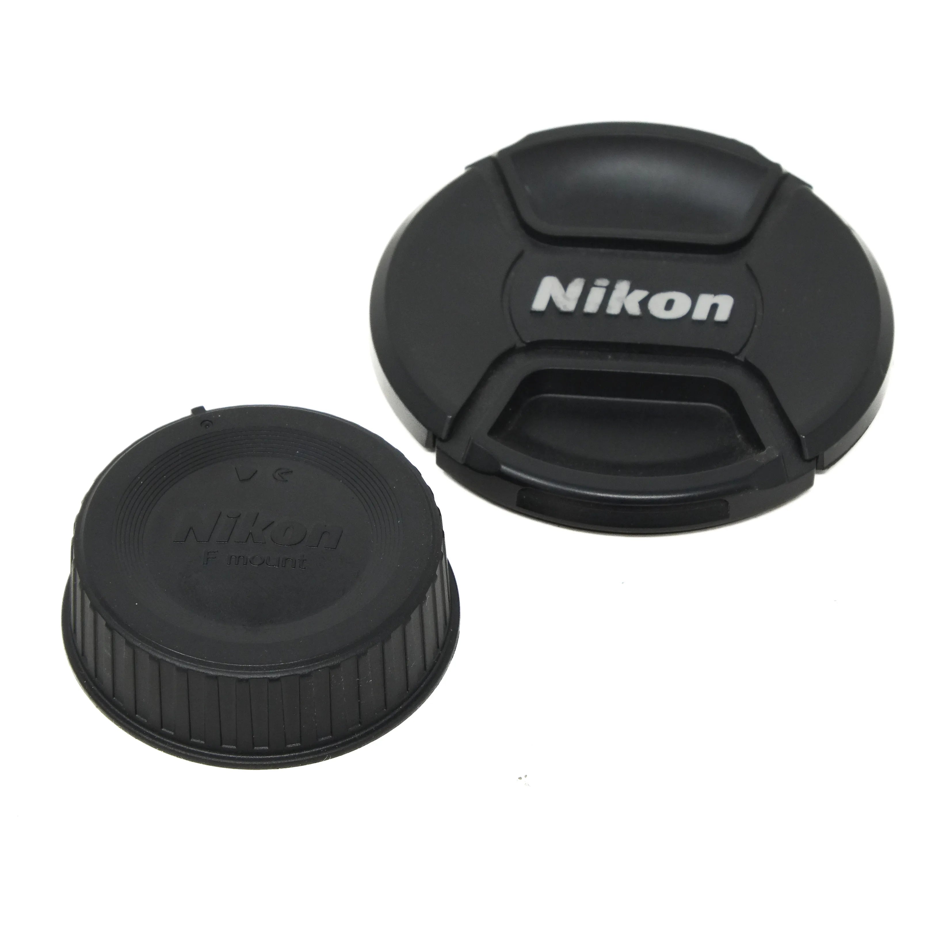 Two Nikon lens caps on a white background