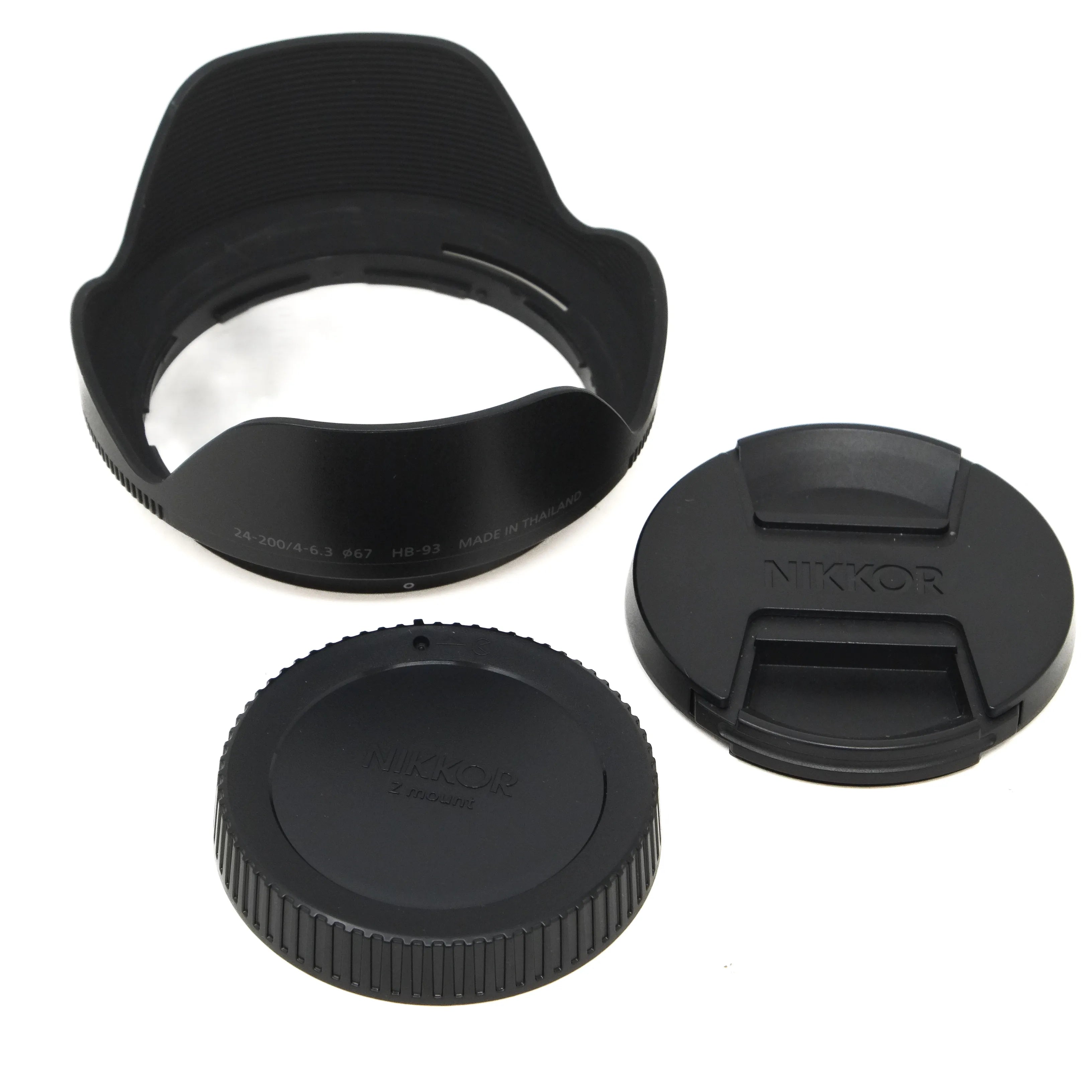 Camera lens accessories including a lens hood, front and rear covers on a white background