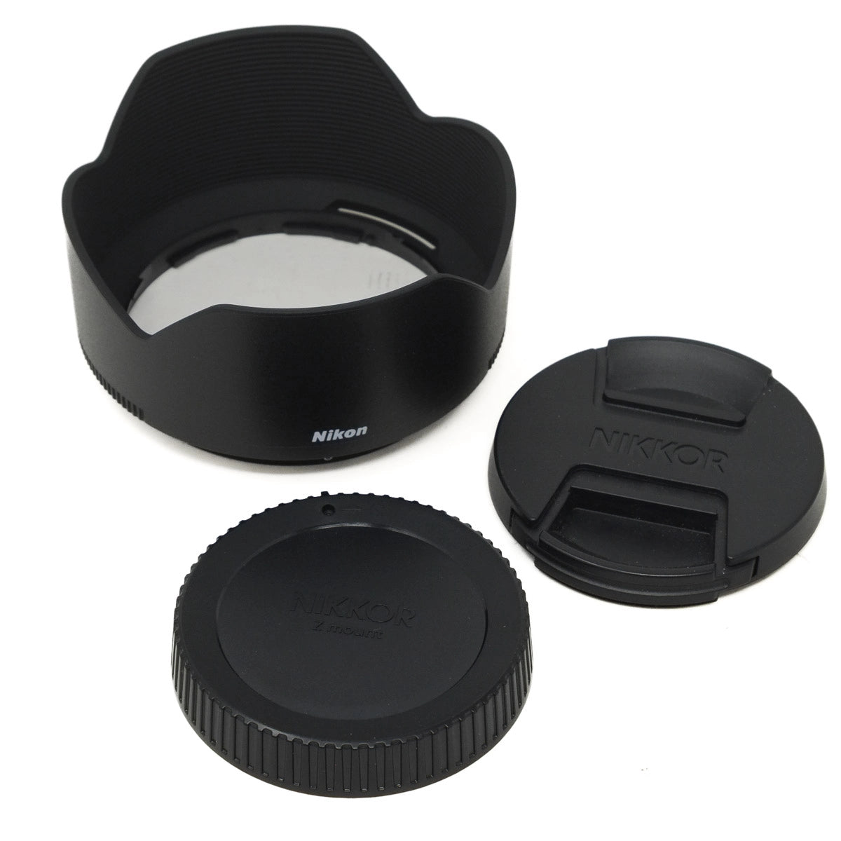 Nikon camera lens accessories including a lens hood, front and rear caps on a white background