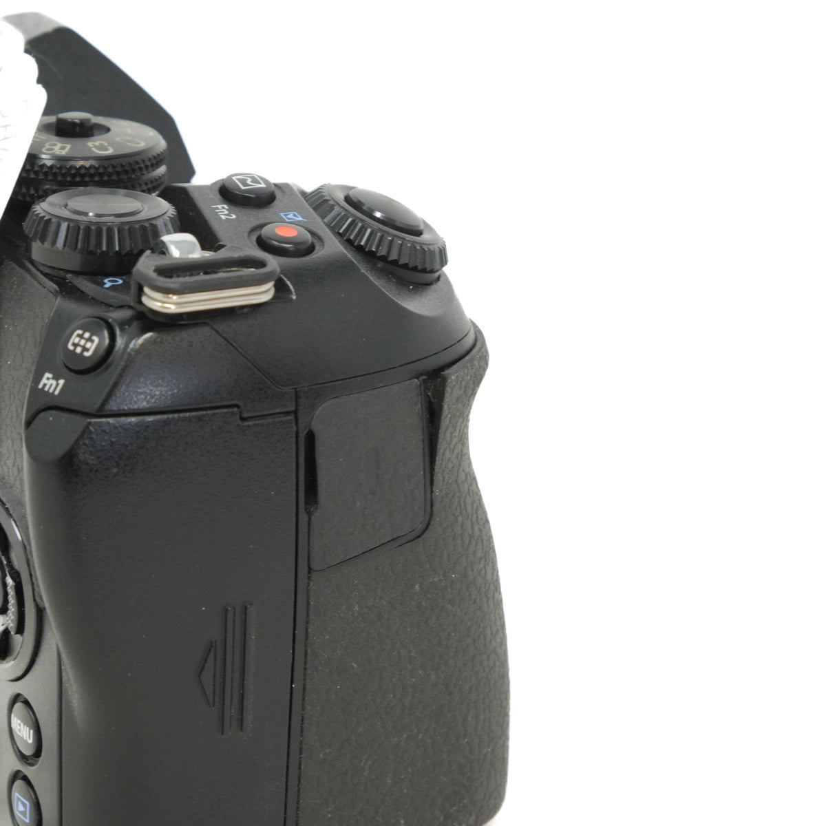 Close-up of a black camera body with control buttons on a white background
