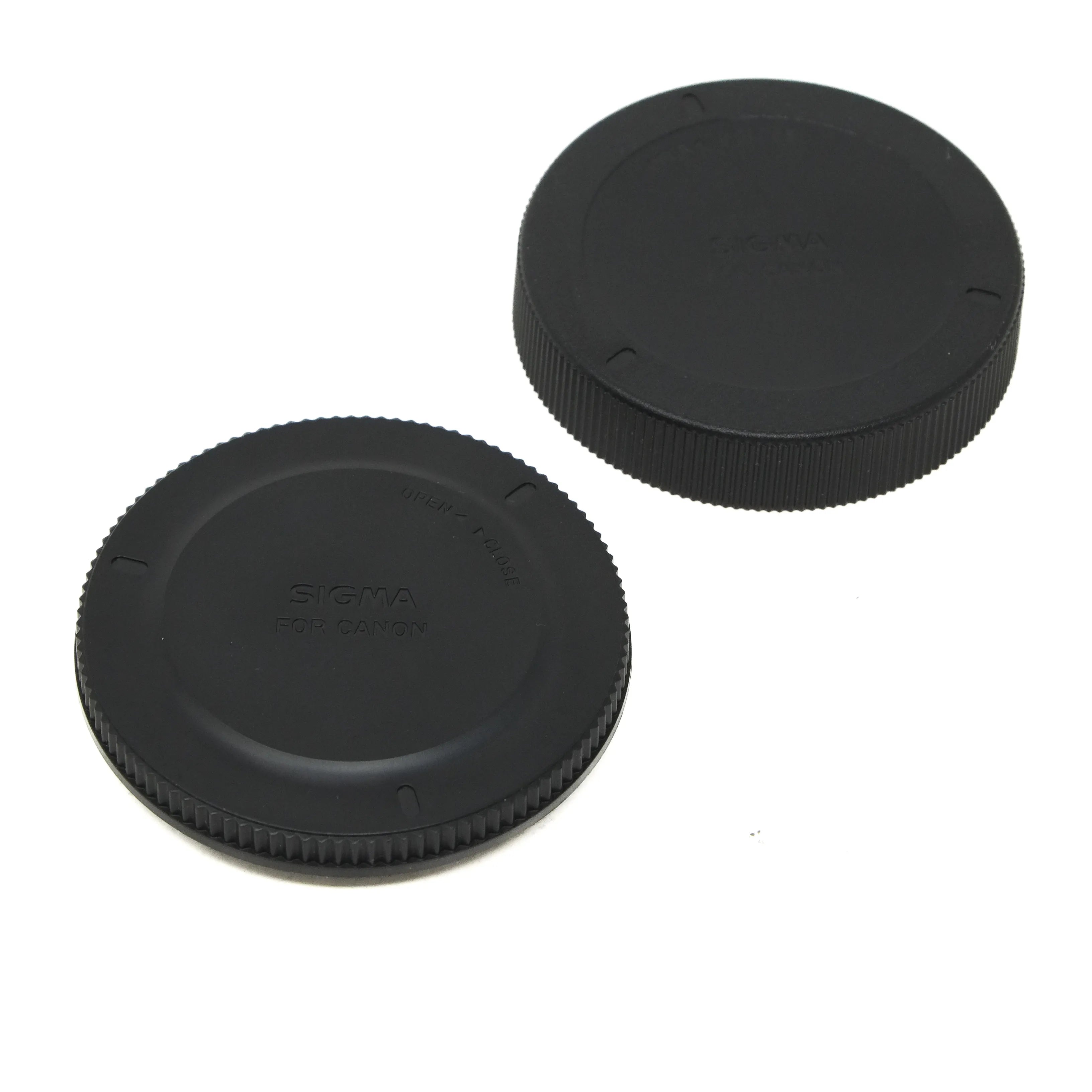 Two black camera lens caps on a white background