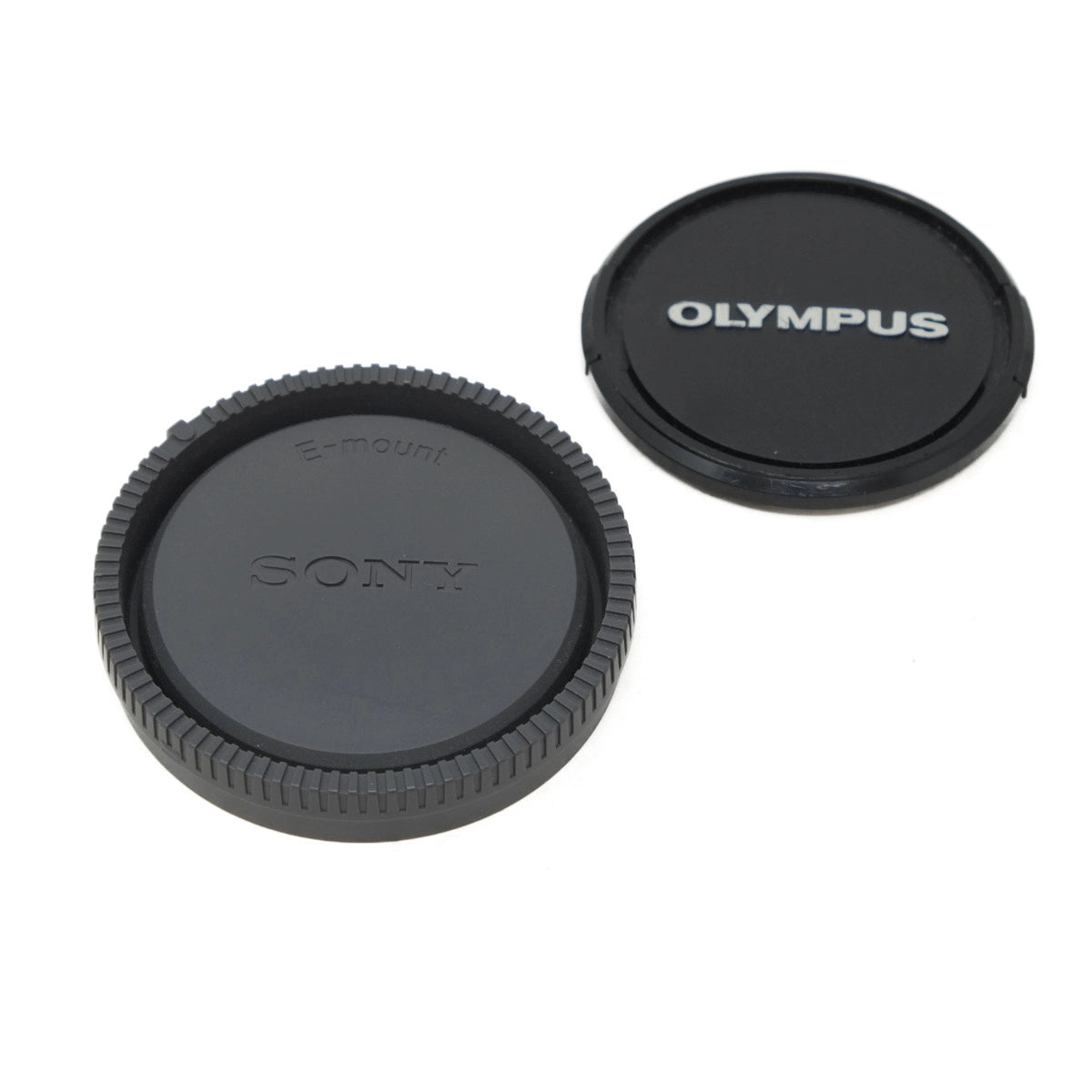 Sony and Olympus camera lens caps on a white background