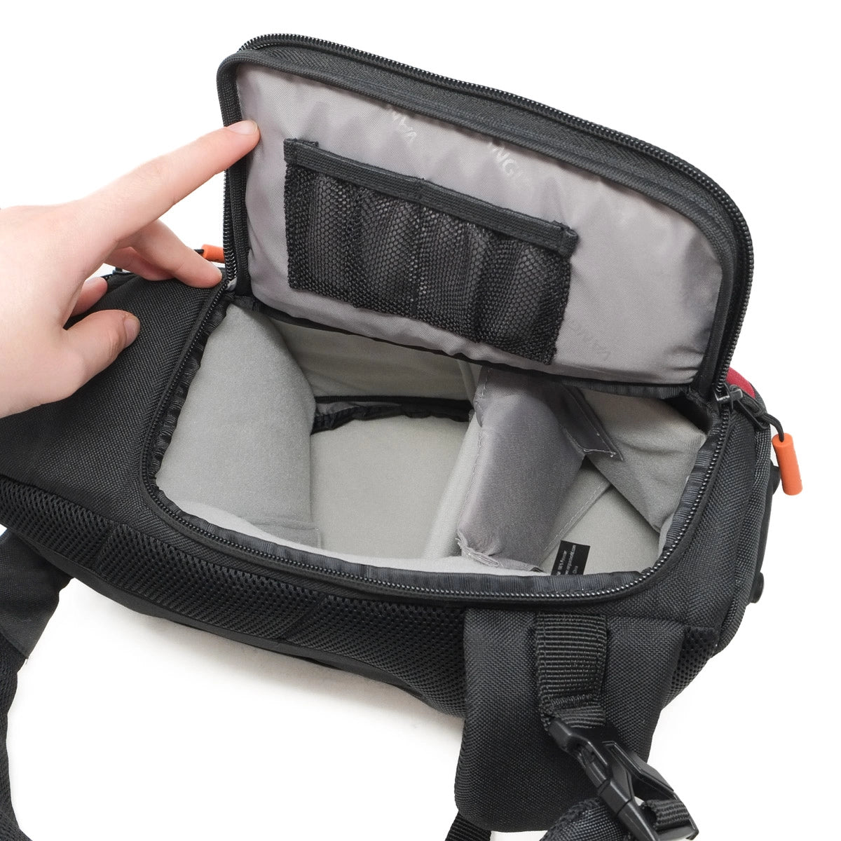 Black camera bag with a hand opening it on a white background