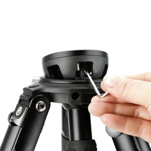 Person adjusting a tripod with a screwdriver on a white background