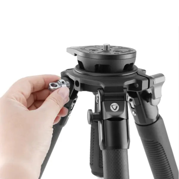 Hand adjusting a camera tripod on a white background