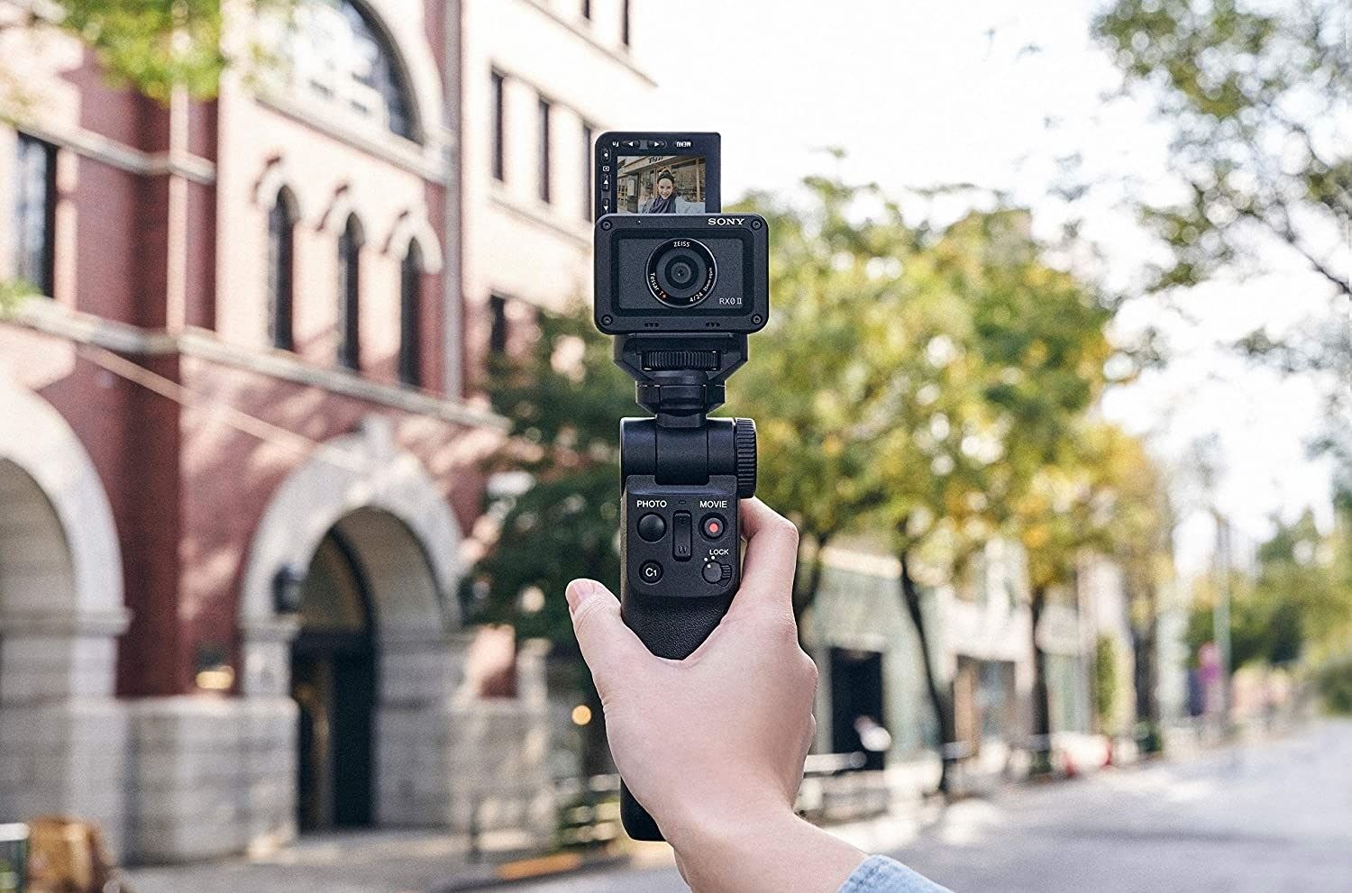 Sony Shooting Grip With Wireless Remote Commander GP-VPT2BT - Product Photo 6 - Alternative lifestyle photo of the grip being used with a smaller camera attached in an urban setting