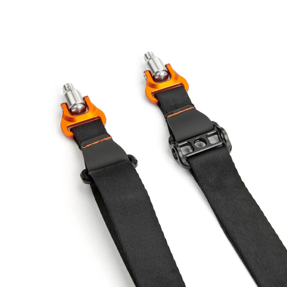 a black camera strap with orange and silver hardware on a white background