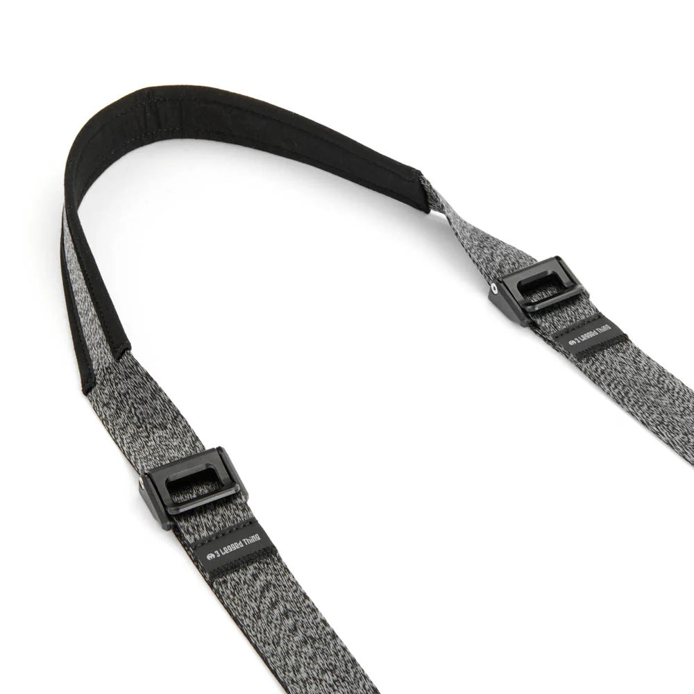 Gray and black camera strap with black buckles on a white background