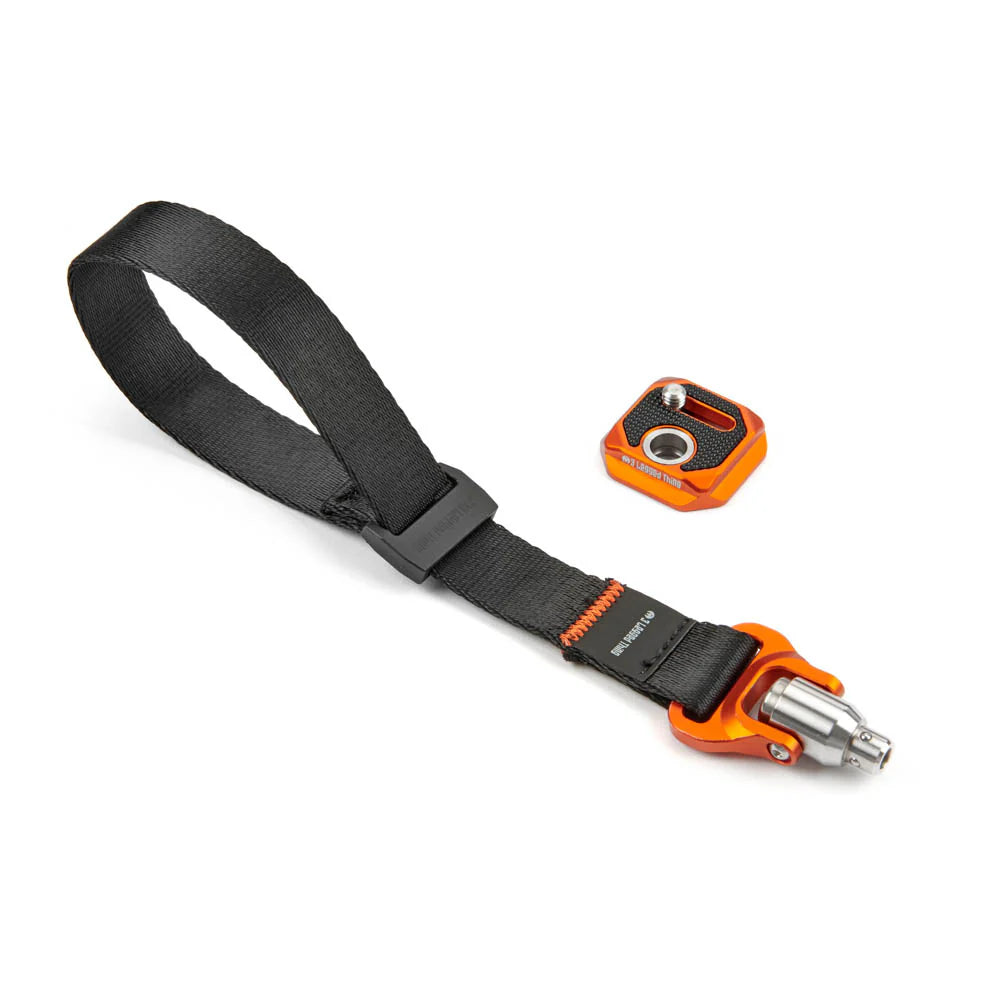Black strap with orange and silver metal clasp on a white background
