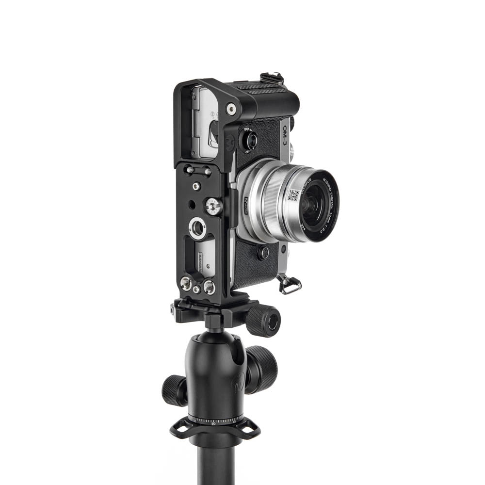 A silver camera body with a silver lens attached to a black tripod mount, photographed against a plain white background.