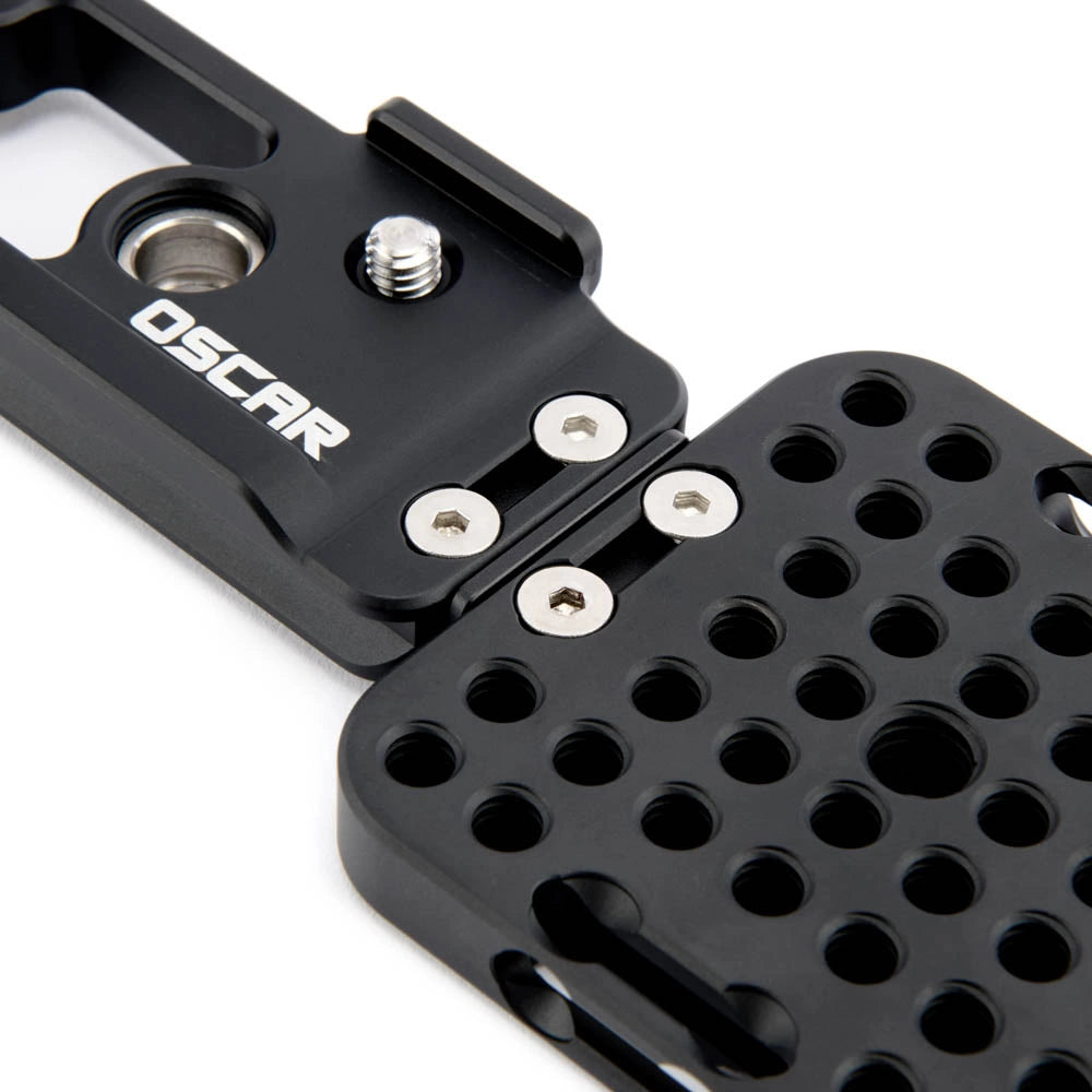 Close-up of a black metal mounting bracket or camera accessory with visible screws and the OSCAR logo on a white background.