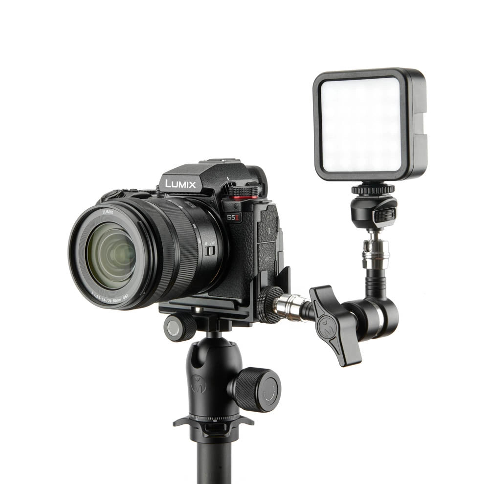 A black Lumix camera with a large lens mounted on a tripod, attached to a flexible arm holding a square LED light panel, shown against a plain white background.