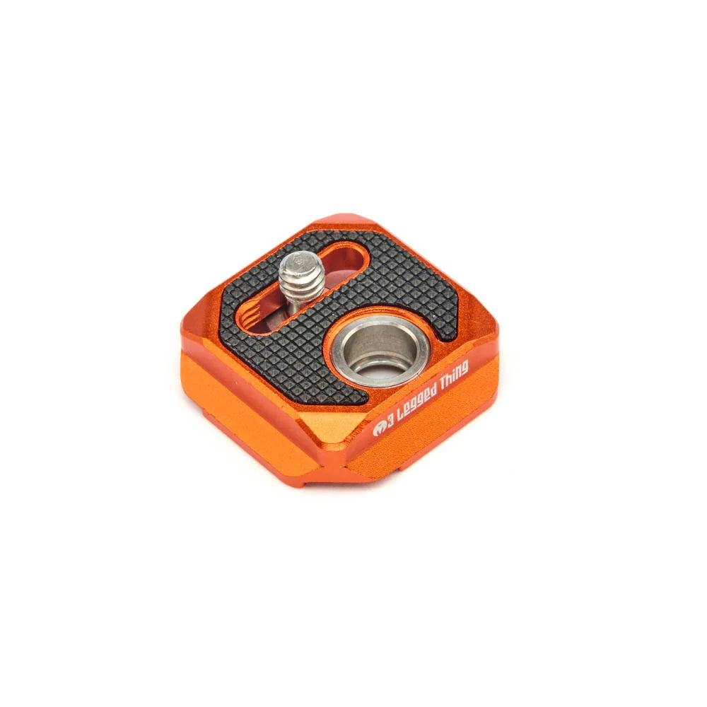 Orange metal tripod plate with threaded holes on a white background