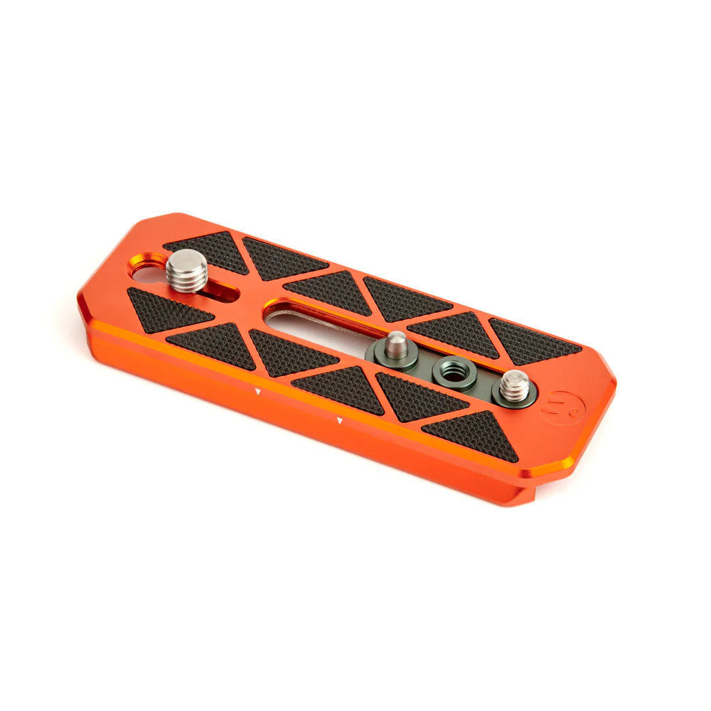 Orange metal plate with black textured surface and screws on a white background