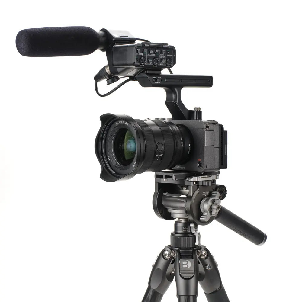 Professional video camera with microphone on a tripod against a white background