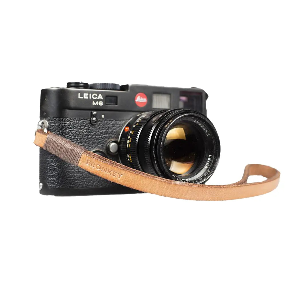 Leica camera with a leather strap on a white background