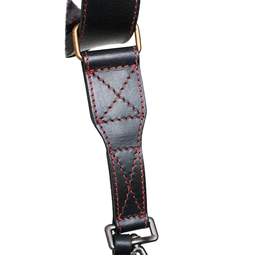 Close-up of a black leather strap with red stitching on a white background