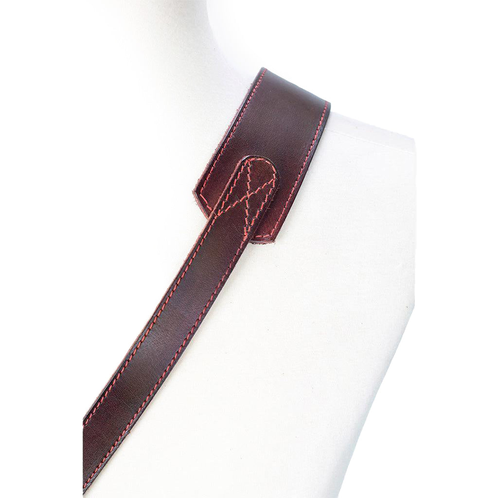 Brown leather guitar strap with red stitching on a white background