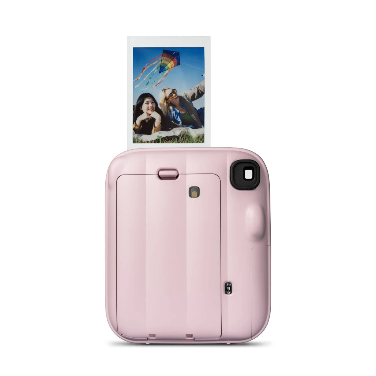 Pink instant camera with a printed photo of a couple and kite on a white background