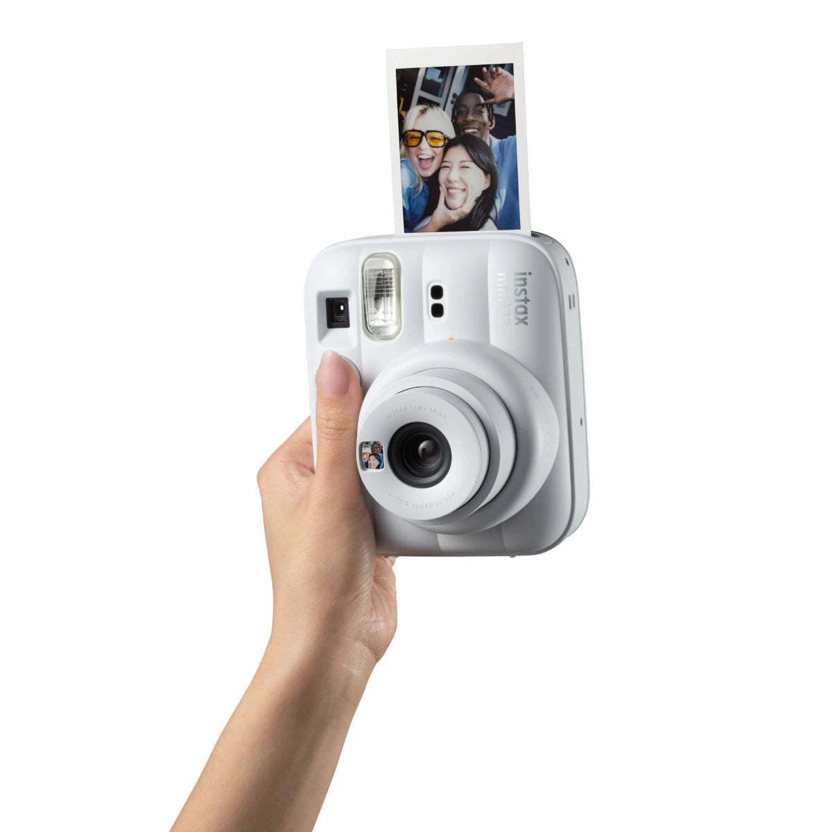 Hand holding a white instant camera with a photo on a white background