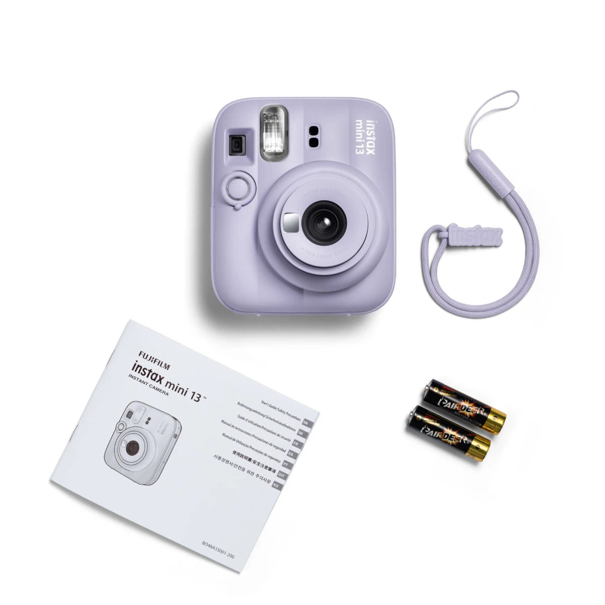 Lavender instant camera with strap, batteries, and manual on a white background