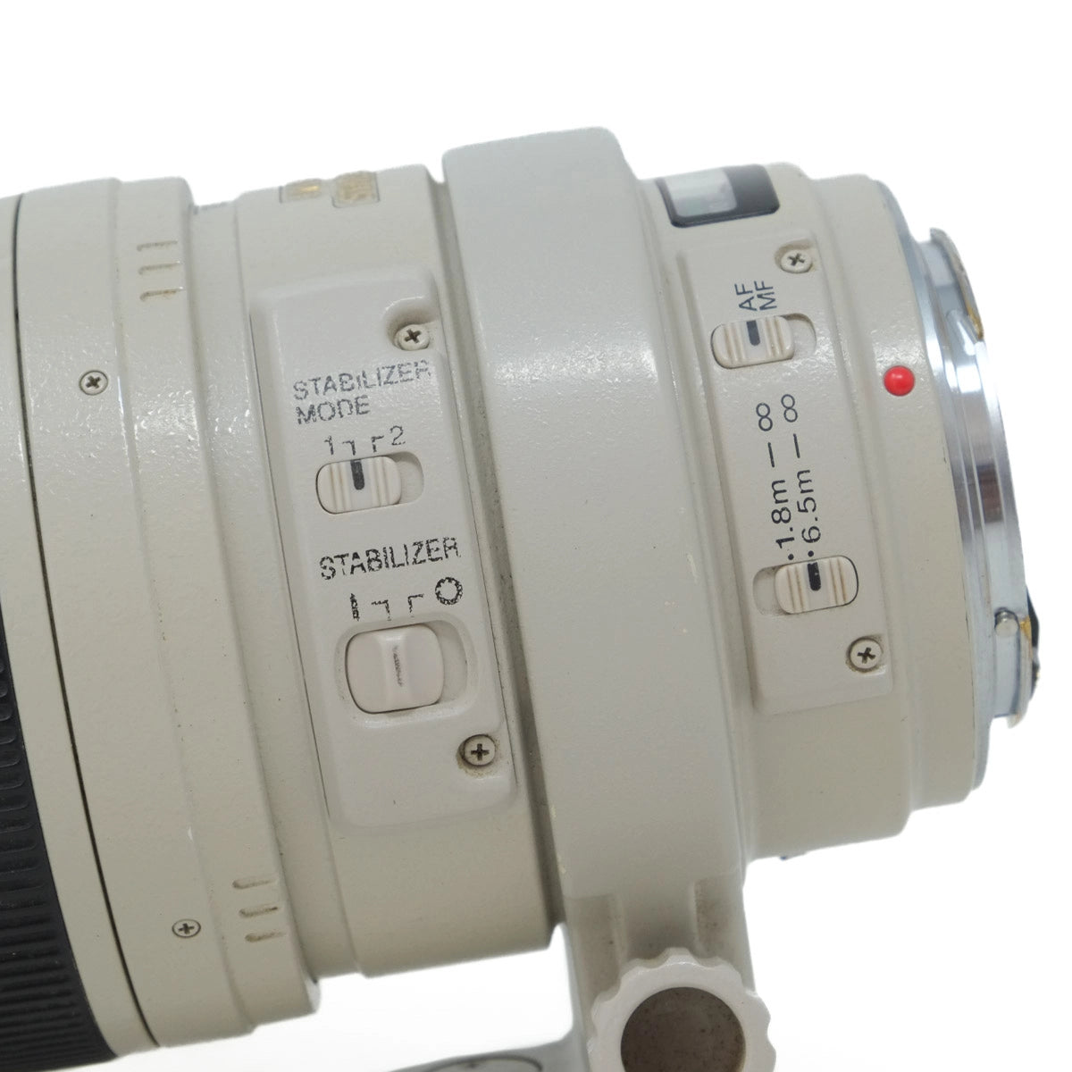 Close-up of a camera lens with control buttons on a white background