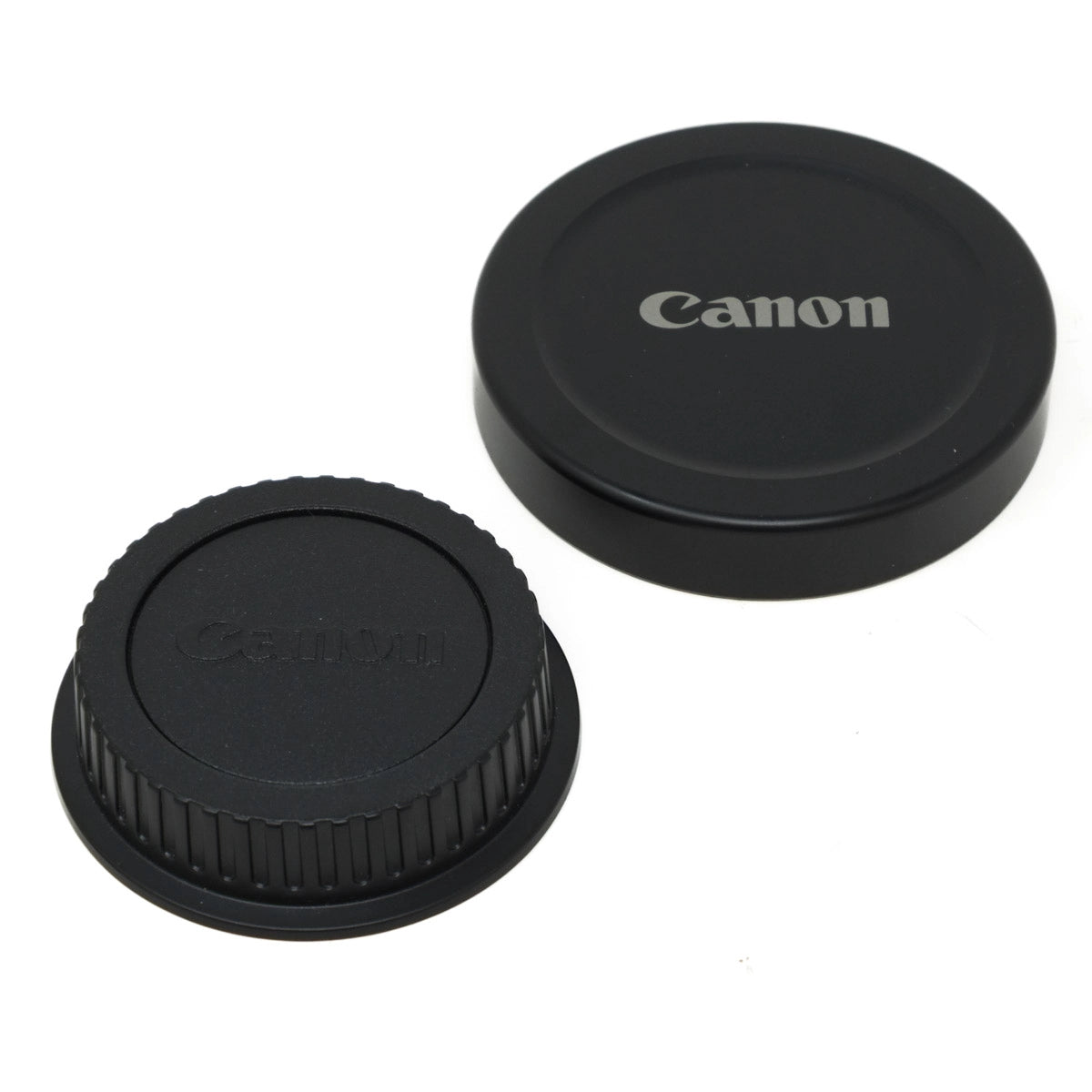 Two black camera lens caps with 'Canon' branding on a white background