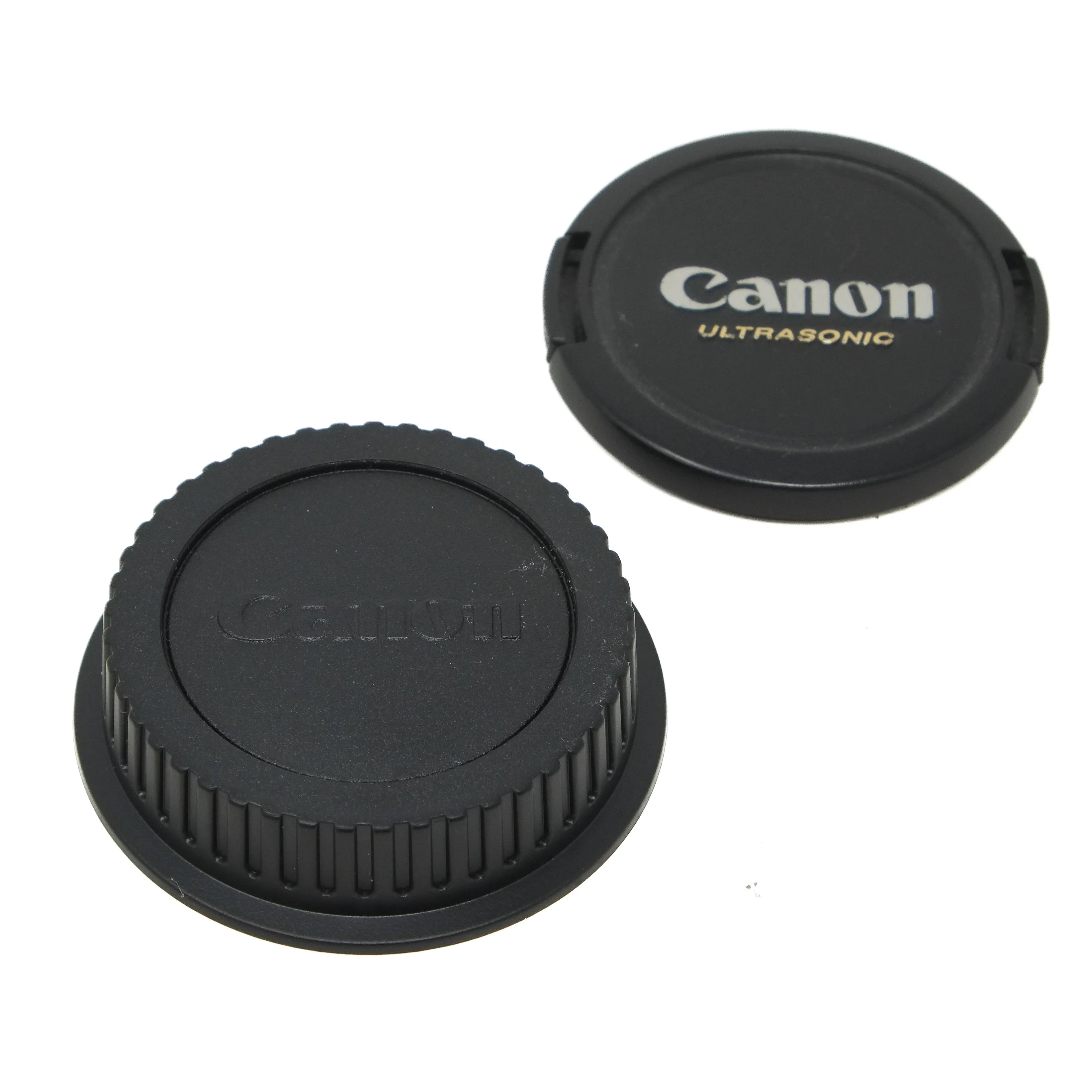 Two black camera lens caps with 'Canon' branding on a white background