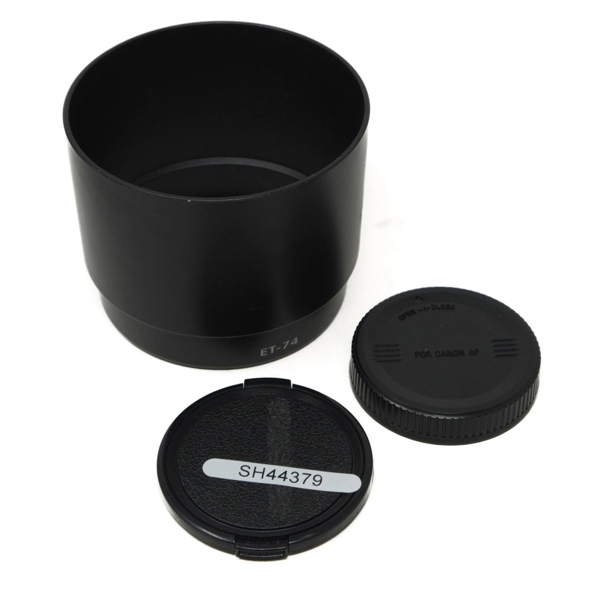 Black camera lens hood and two caps on a white background