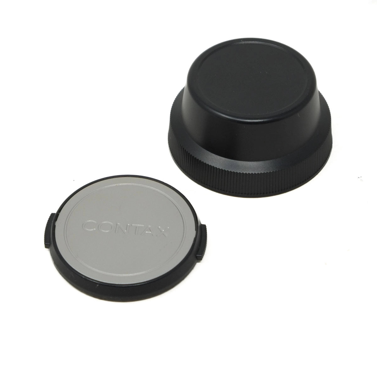 Two camera lens caps, one black and one gray with 'Contax' branding, on a white background.