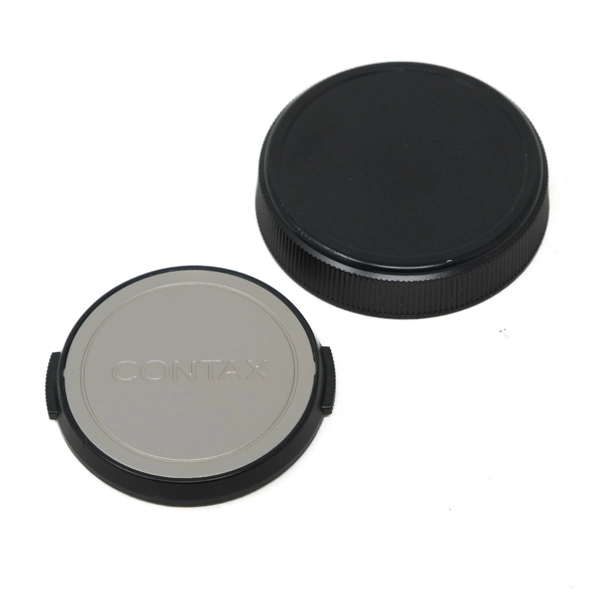 Two camera lens caps, one black and one gray with 'Contax' branding, on a white background.