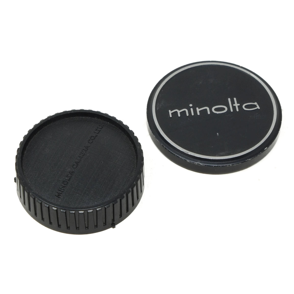 Two black camera lens caps with 'Minolta' branding on a white background