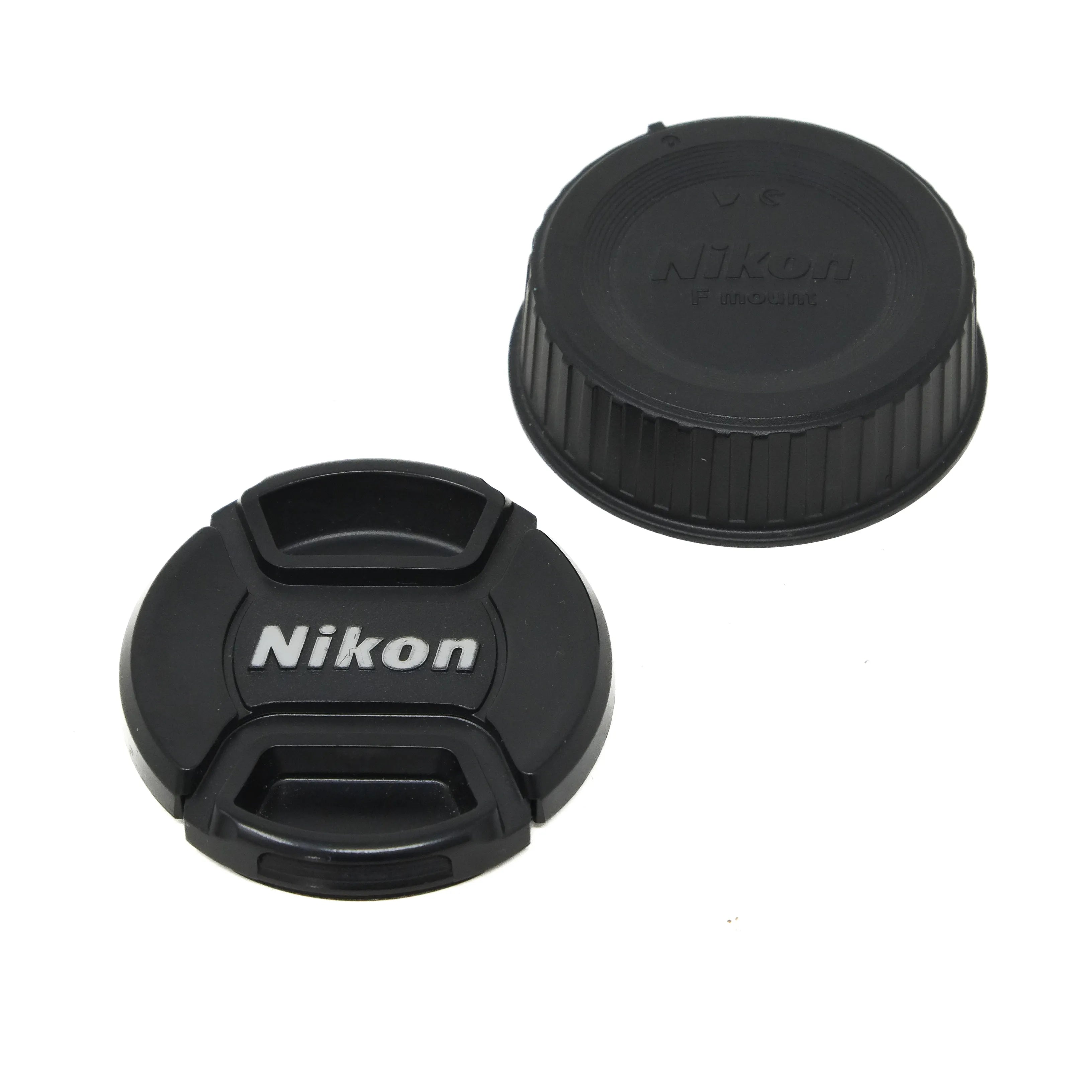 Two Nikon lens caps on a white background